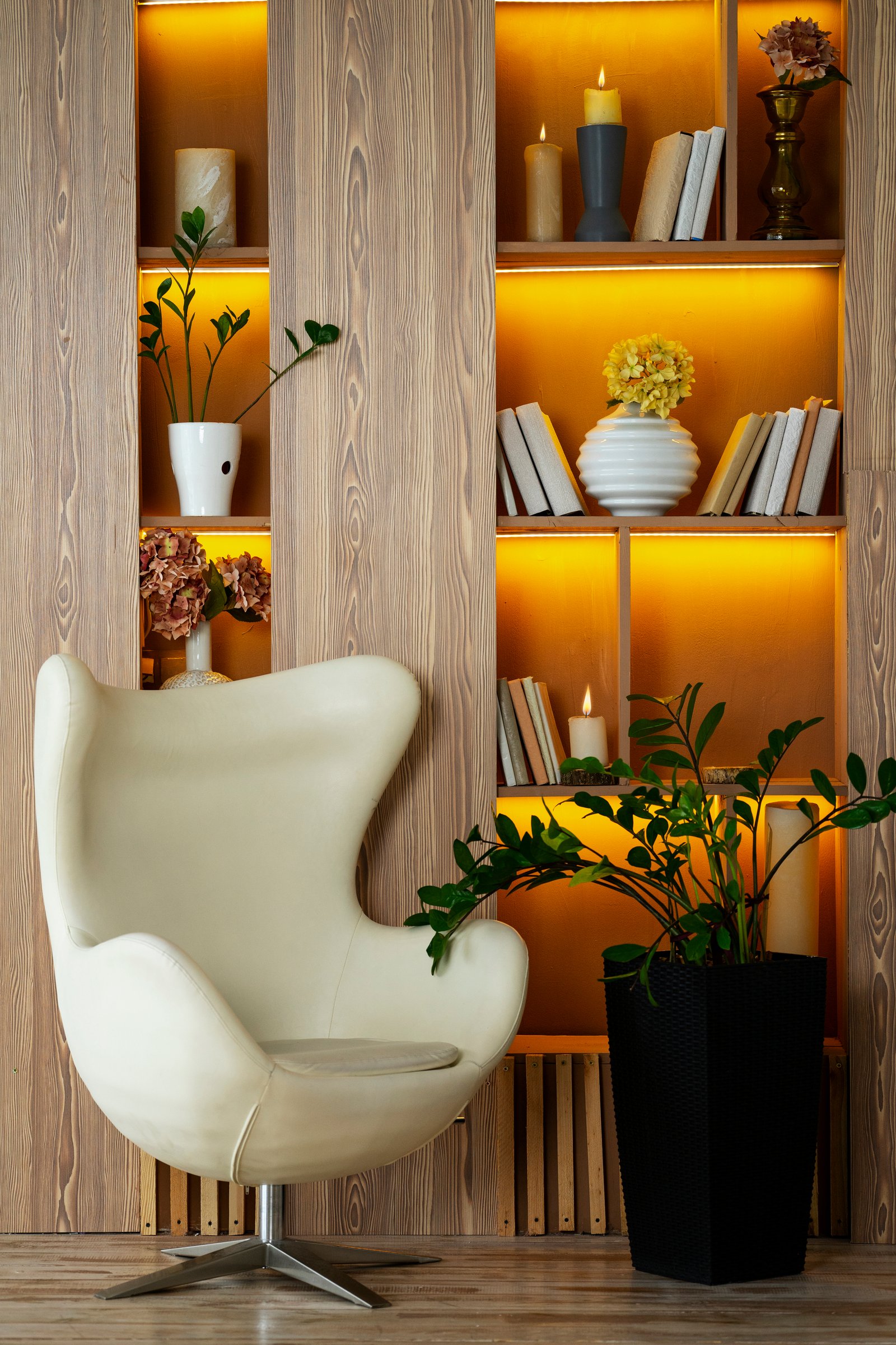 Sculptural chair beside a lit bookshelf